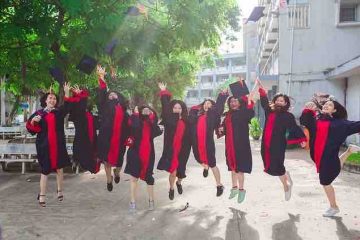 Friends jumping with joy at college graduation depicting happiness, friendship, memories, and a good life.