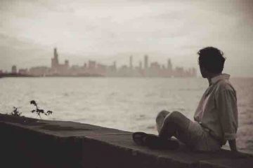 A Man sitting by the seaside alone and thinking something depicting lost love, misery, and pain.