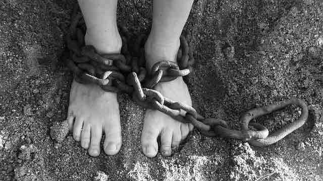 Chain tied to the legs suggesting slavery, depression, and misery.