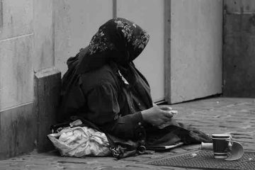 A beggar on the street in miserable state depicting poverty.