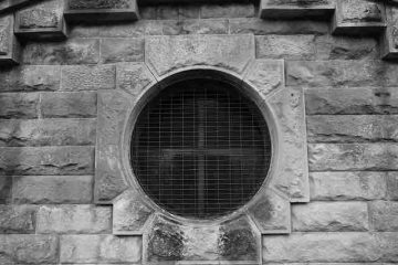 A window in the wall of a prison with dark inside depicting guilt, emptiness, and misery.