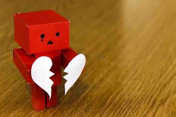 A box character crying and holding a torn heart shaped paper depicting broken love, pain, and misery.
