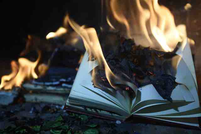 Pages of a book burning depicting torn emotions, dark past, and broken relationship.