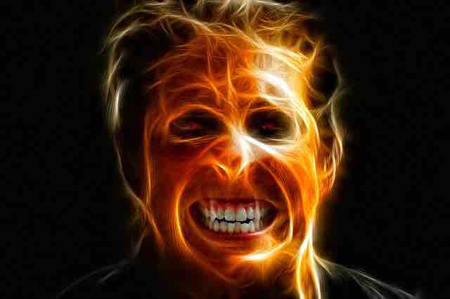 A man in agony with his face burning from the inside depicting emotions, depression, pain, and misery.