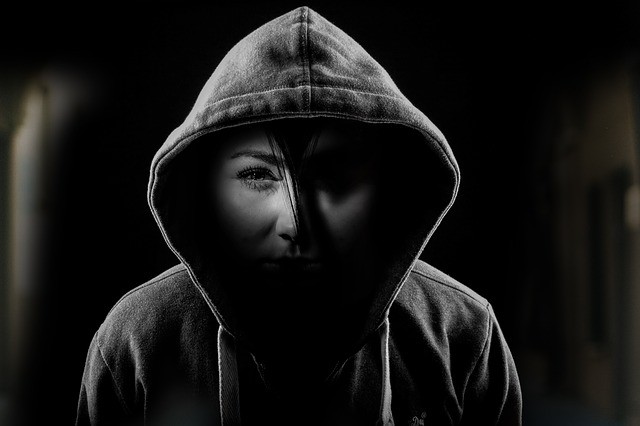 Songs about depression and bipolar disorder. A woman with a hoodie and one side of the face in dark and other in the light depicting two sides of bipolar disorder.