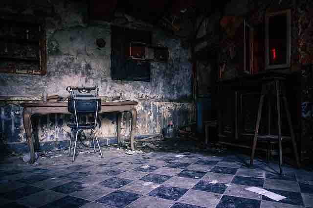 Poems on pain: Untidy and empty dark room with only a chair and a table depicting past memories, misery and pain.