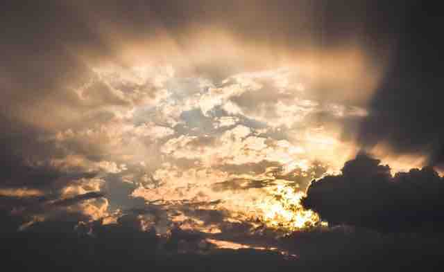 Sun rays penetrating through the cloudy sky depicting hope.
