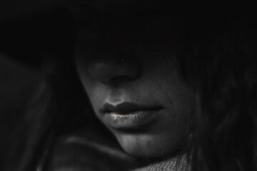 Girl with a hoodie in the darkness depicting depression, misery, and pain