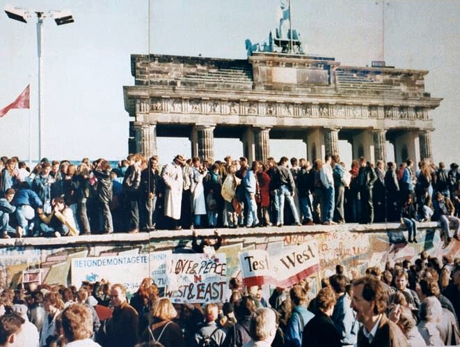 Germans standing near the Berlin Wall during its fall marking the end of Cold War
